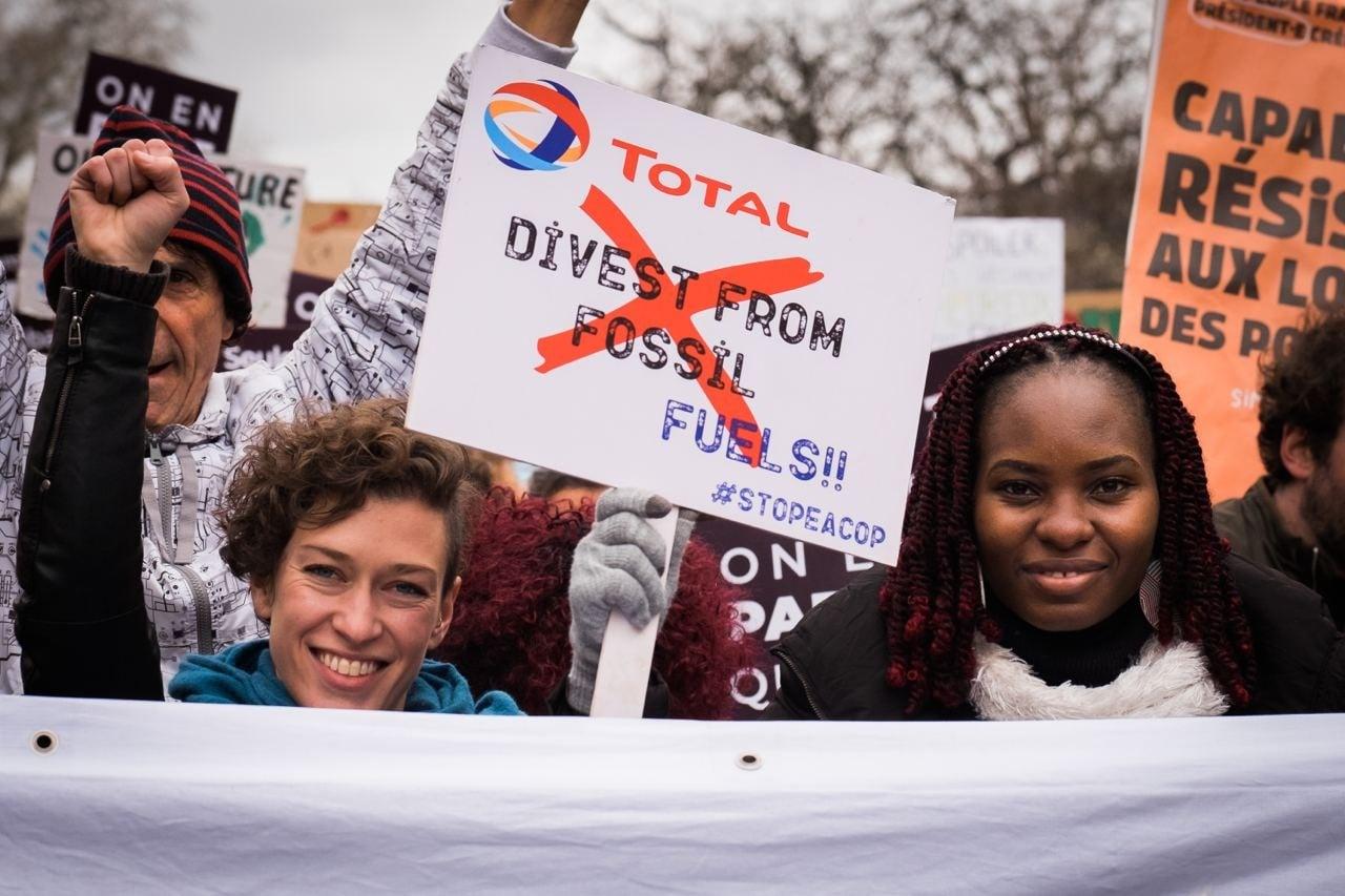 Betogers met spandoek 'Divest from fossil fuels! #stopeacop'