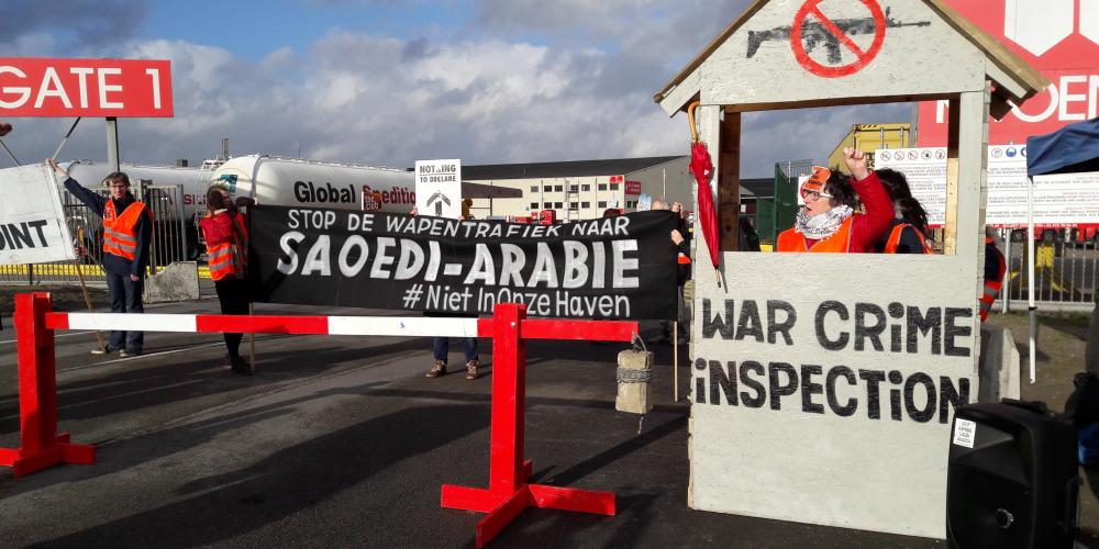 Action at the port of Antwerp - banner says stop arming saudi in Dutch