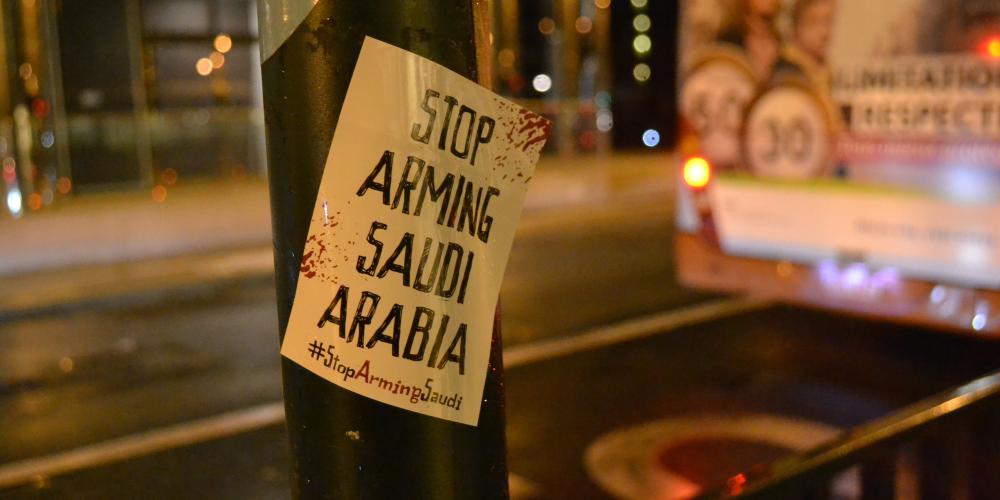 de foto toont een sticker op een lantaarnpaal met daarop Stop Arming Saudi Arabia