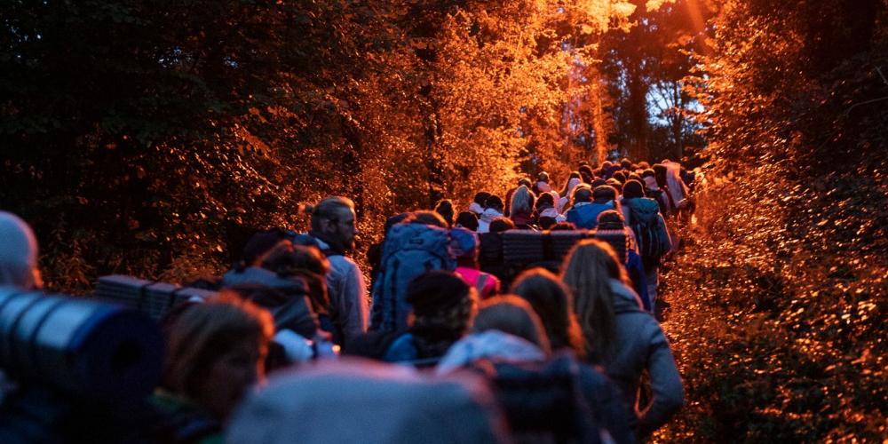 Een groep mensen wandelt 's ochtends vroeg naar de actieplek