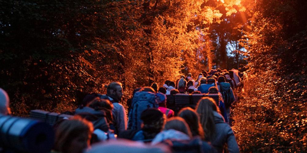 Een groep mensen wandelt 's ochtends vroeg naar de actieplek