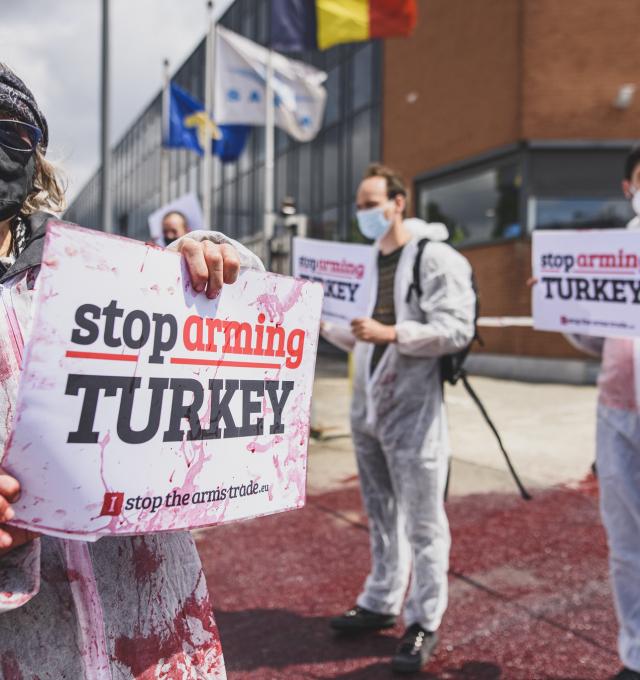 activisten voeren actie bij wapenbedrijf sabca - ze houden bordjes vast waarop "Stop Arming Turkey" staat